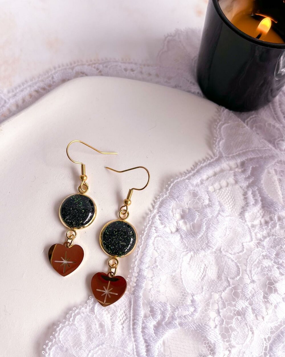 Boucles dorées en acier inoxydable avec médaillon noir de 12 mm serti de sable d’aventurine verte et breloque cœur avec étoile ajourée.