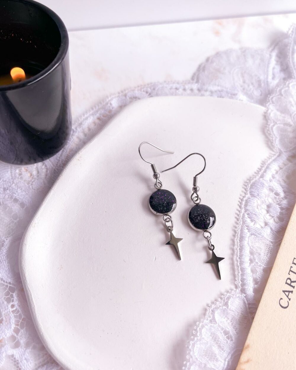 Boucles argentées en acier inoxydable avec médaillon noir de 10 mm incrusté de sable d’améthyste et de paillettes violettes, breloque étoile à quatre branches.