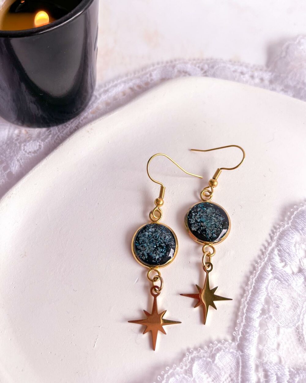 Boucles dorées en acier inoxydable avec médaillon noir de 12 mm serti de poudre de turquoise et étoile ciselée suspendue.