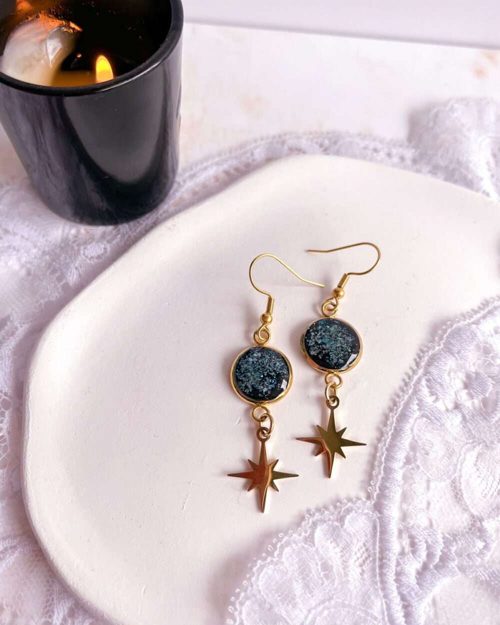 Boucles dorées en acier inoxydable avec médaillon noir de 12 mm serti de poudre de turquoise et étoile ciselée suspendue.