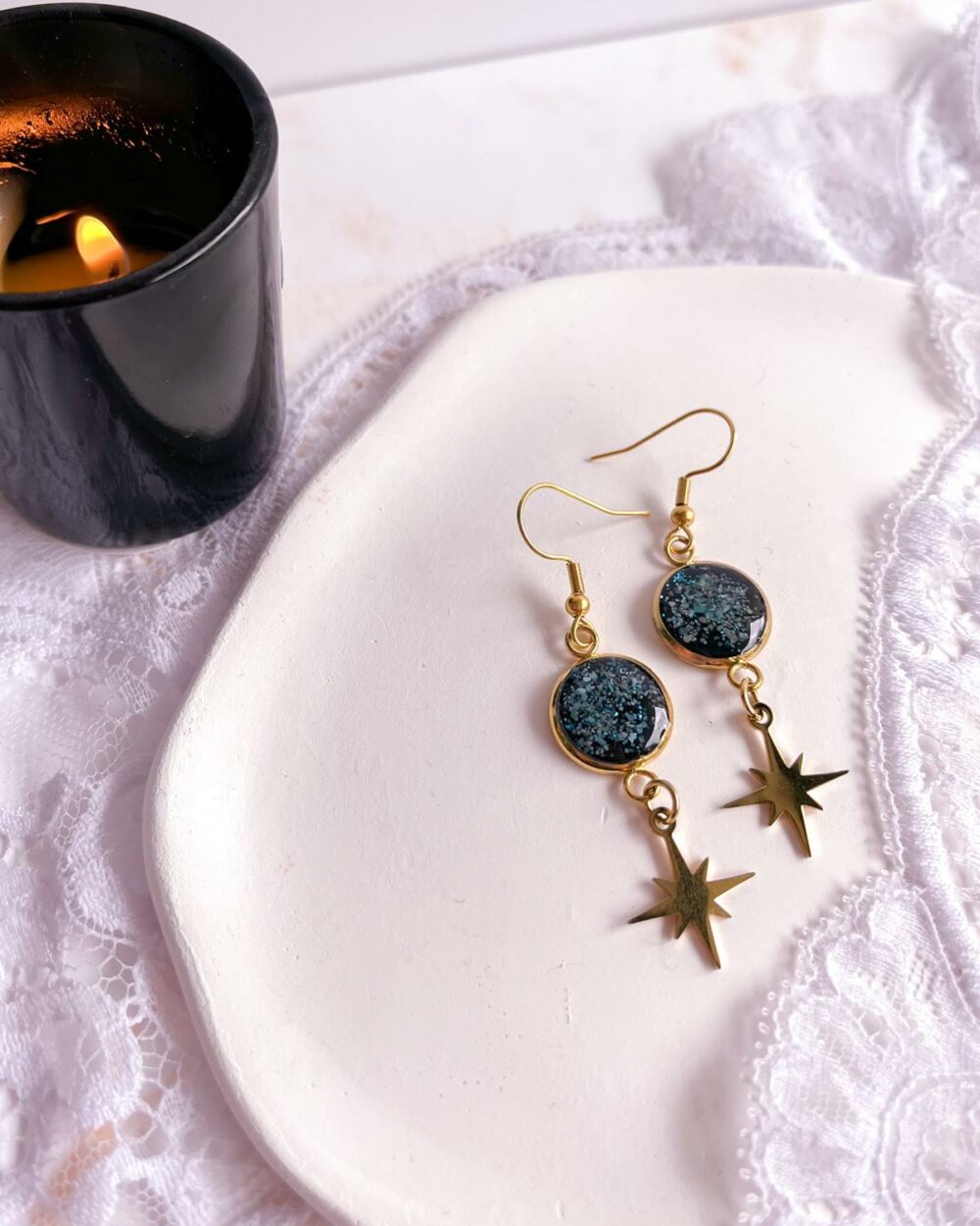 Boucles dorées en acier inoxydable avec médaillon noir de 12 mm serti de poudre de turquoise et étoile ciselée suspendue.