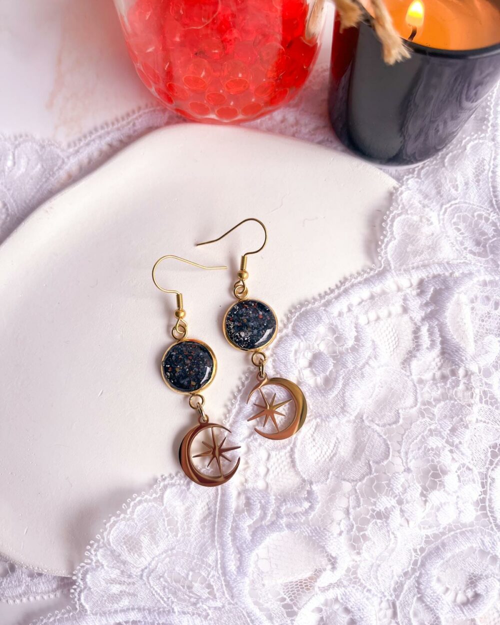 Boucles dorées en acier inoxydable avec médaillon noir de 12 mm serti de sable de cornaline et breloque lune contenant une étoile.