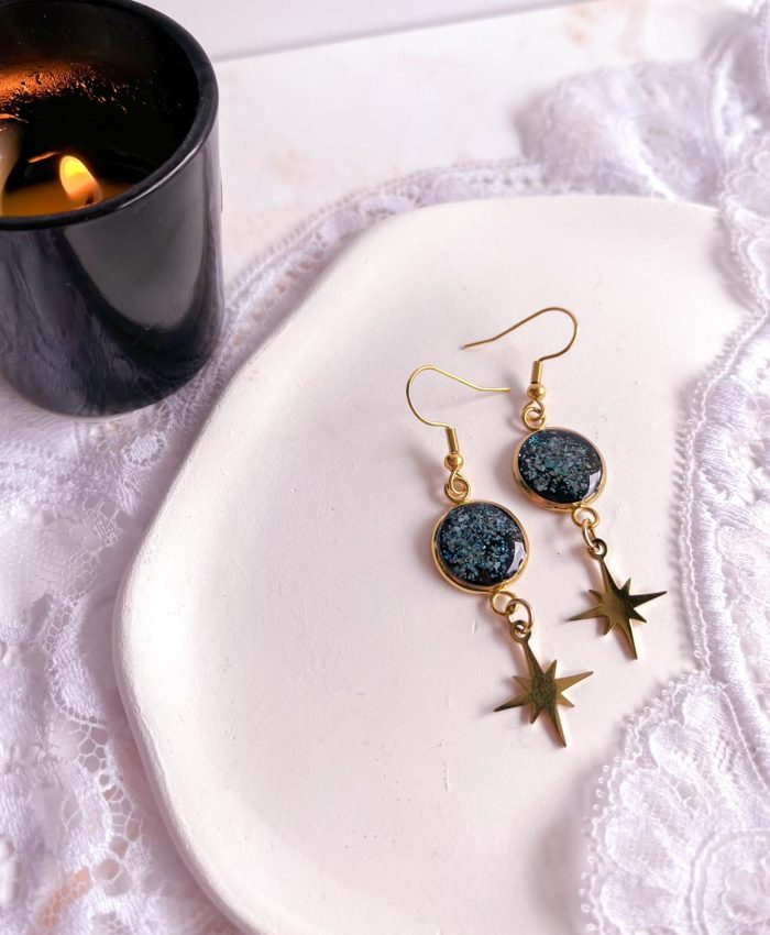 Boucles dorées en acier inoxydable avec médaillon noir de 12 mm serti de poudre de turquoise et étoile ciselée suspendue.